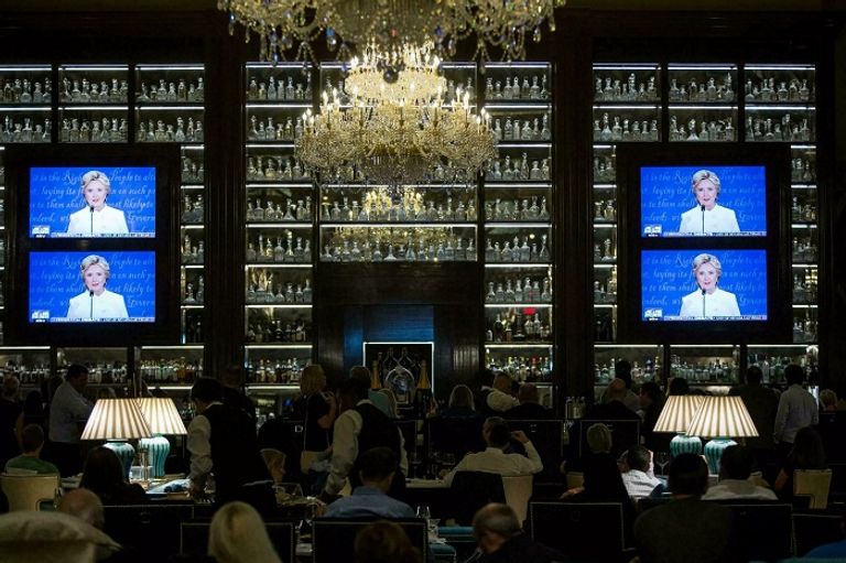 نزلاء في الفندق يُشاهدون المناظرة التلفزيونية الثالثة بين هيلاري كلينتون ودونالد ترامب في 2016  - أ ف ب