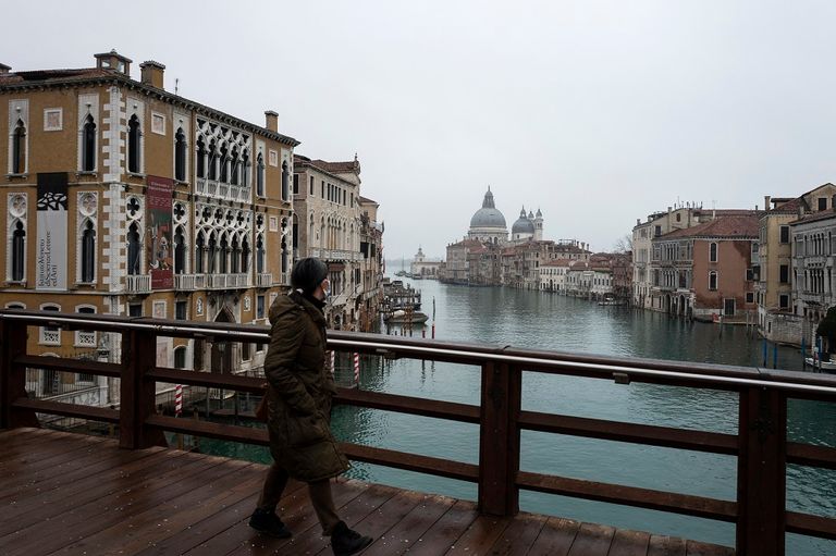  امرأة تمشي عبر جسر Accademia أمام القناة الكبرى في البندقية