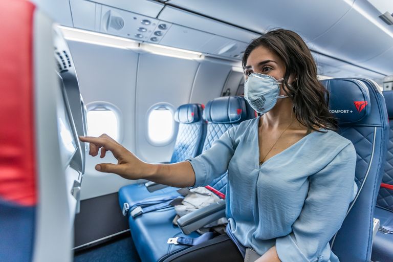 مسافرة على متن طائرة ترتدي كمامة للوقاية من فيروس كورونا المستجد - أرشيفية